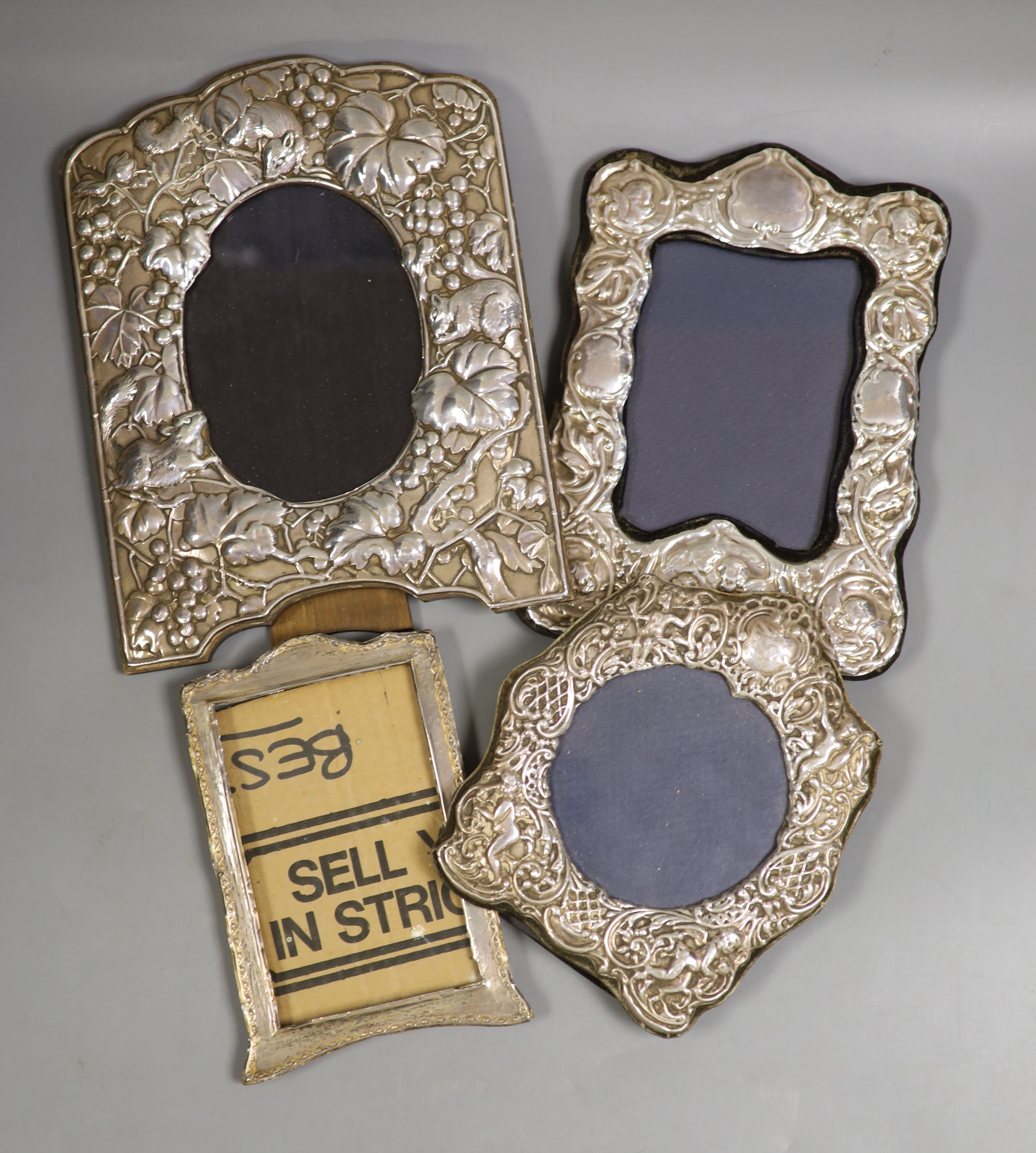 Four assorted modern silver mounted photograph frames including three with repousse decoration, largest 24.8cm.